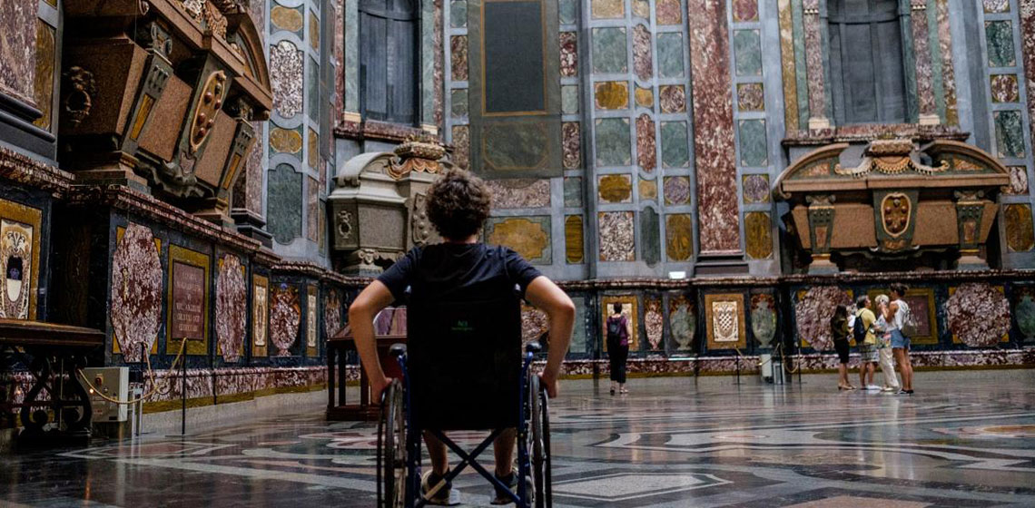 Accessibilità ai musei e monumenti a Firenze, un ragazzo su sedia a rotelle che visita una chiesa